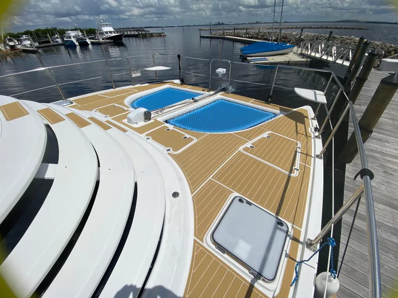 Slide: The Image of 2007 Manta 44 Power Cat docked, featuring spacious deck and scenic marina view. - 8