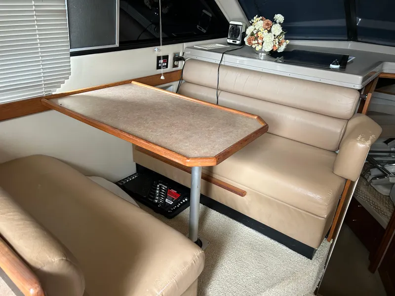 Slide: The Image of Interior of 2000 Bayliner 4087 Motoryacht with beige seating and wooden table. - 12