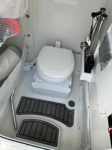 Slide: The Image of 2022 Sea Hunt Ultra 265 SE boat bathroom with toilet and storage features. - 10