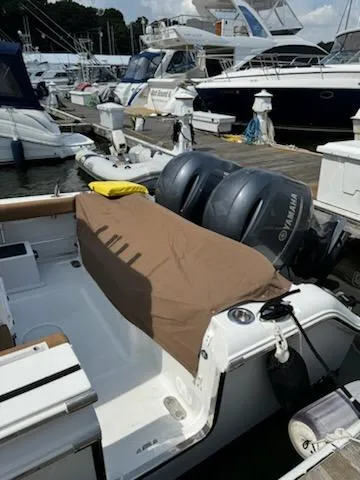 Slide: The Image of 2022 Sea Hunt Ultra 265 SE boat docked with twin Yamaha engines, covered seating area. - 12