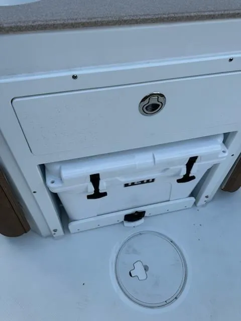 Slide: The Image of 2022 Sea Hunt Ultra 265 SE boat storage compartment with cooler and latch. - 9