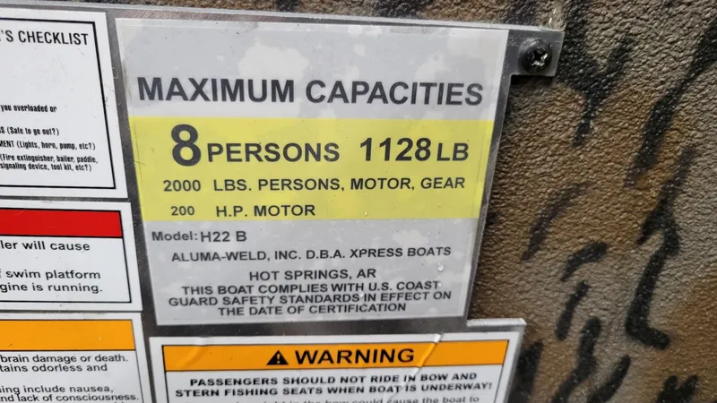 Slide: The Image of Capacity label for 2025 Xpress H22 Bay boat, max 8 persons, 1128 lbs, 200 HP motor. - 10