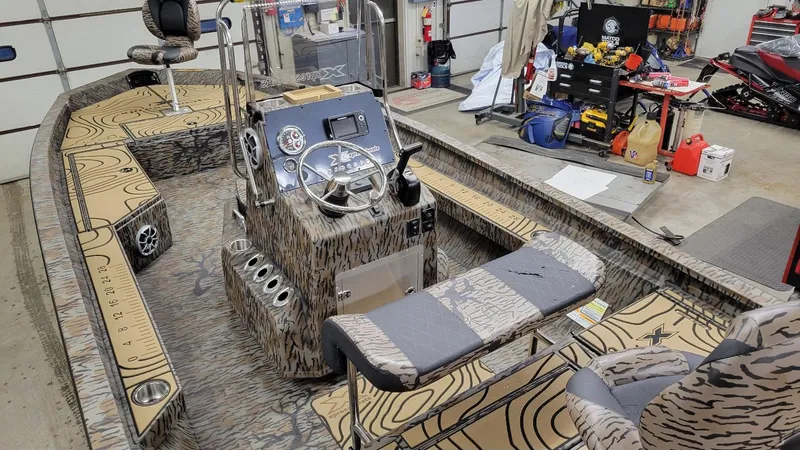 Slide: The Image of 2025 Xpress H22 Bay boat with Yamaha Vmax 175 SHO, camo interior, in a garage setting. - 4