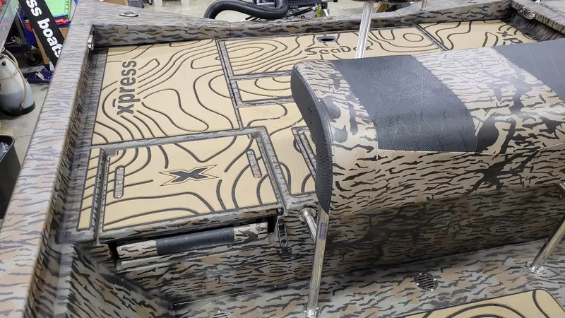 Slide: The Image of 2025 Xpress H22 Bay boat interior with camouflage design and storage compartments. - 9
