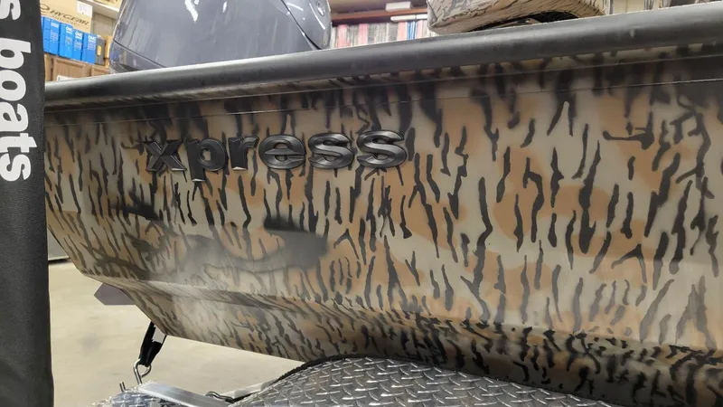 Slide: The Image of 2025 Xpress H210 Bay boat with camouflage design and Yamaha 150 engine. - 12