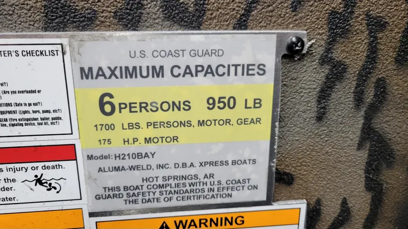Slide: The Image of U.S. Coast Guard capacity label for Xpress H210 Bay, 6 persons, 950 lbs, 175 HP motor. - 18