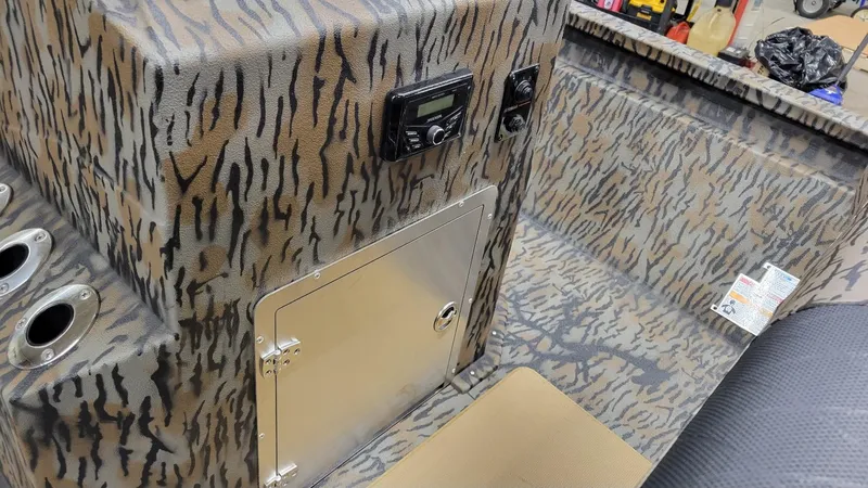 Slide: The Image of 2025 Xpress H210 Bay boat interior with camo design and control panel. - 19