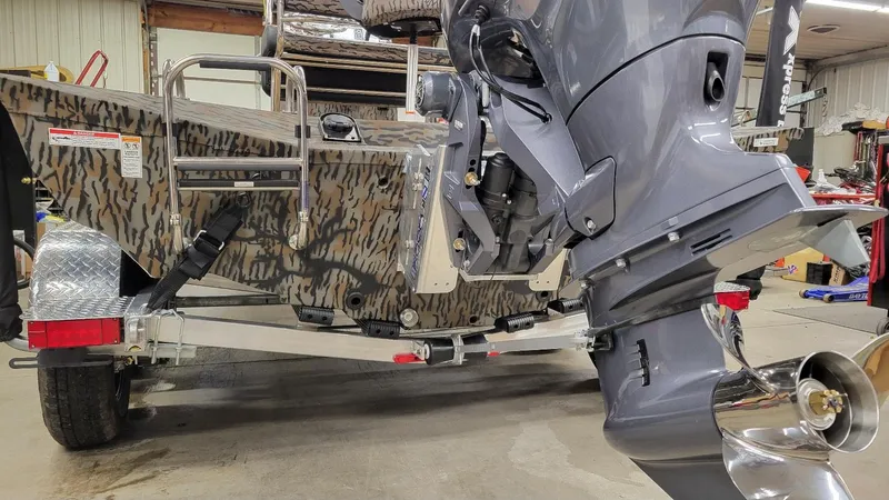 Slide: The Image of 2025 Xpress H210 Bay boat with Yamaha 150 engine, camo design, on trailer. - 3