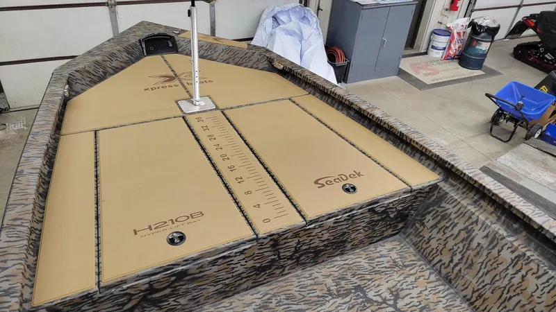 Slide: The Image of 2025 Xpress H210 Bay boat interior with SeaDek flooring and measurement markings. - 5