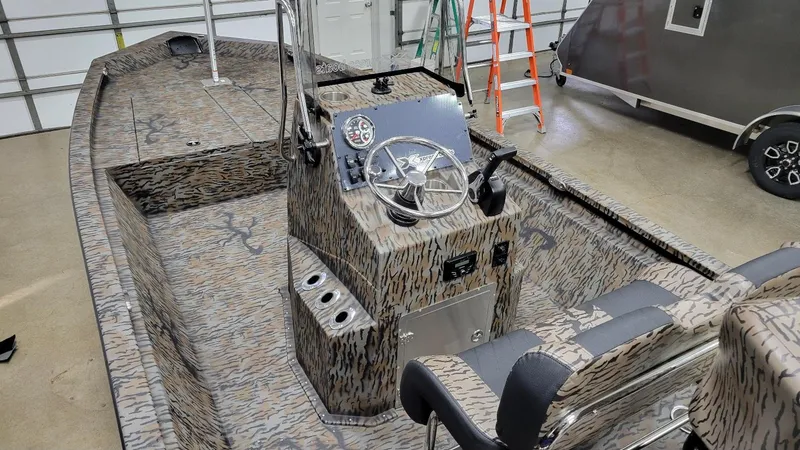 Slide: The Image of 2025 Xpress H210 Bay boat interior with camo design and steering console. - 14