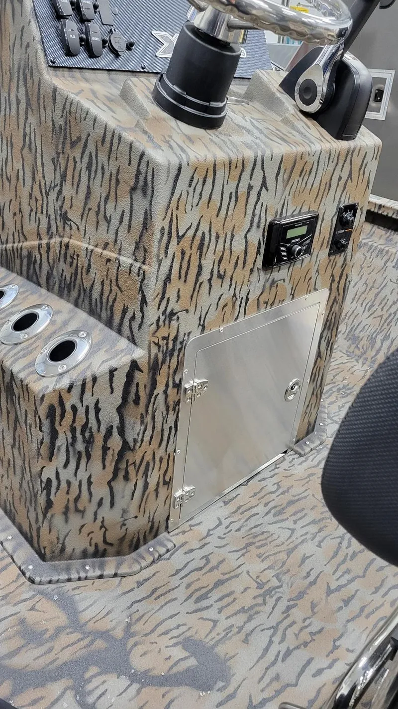 Slide: The Image of 2025 Xpress H210 Bay boat console with camo design and Yamaha F150 engine. - 15