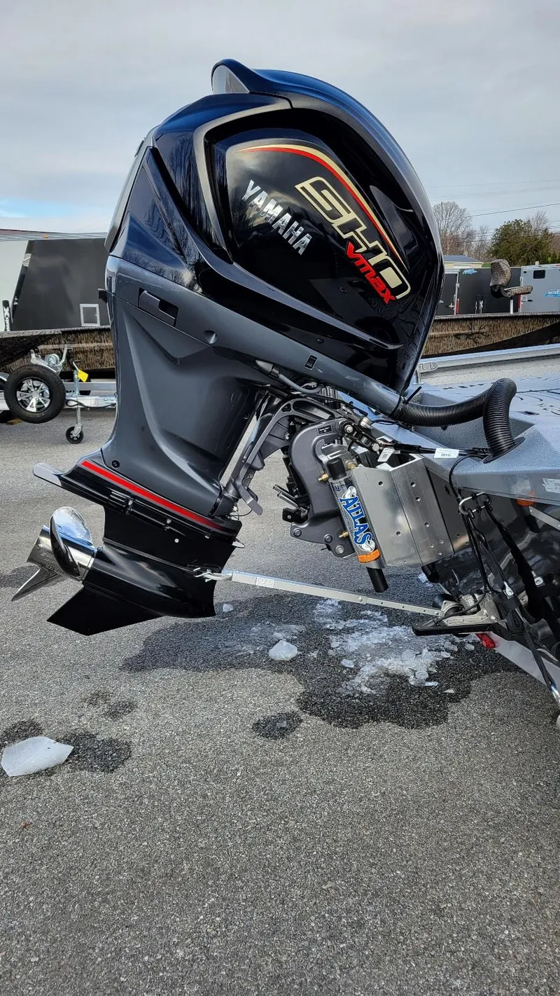 Slide: The Image of 2025 Xpress H22 Bay with Yamaha Vmax 200 SHO outboard motor, parked on pavement. - 2