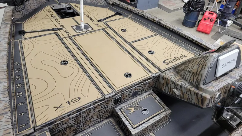 Slide: The Image of 2025 Xpress X19 Pro Bass boat interior with SeaDek flooring and Garmin electronics. - 13