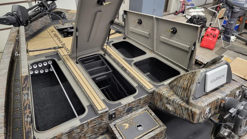 Slide: The Image of 2025 Xpress X19 Pro Bass boat interior with storage compartments and Garmin system. - 14