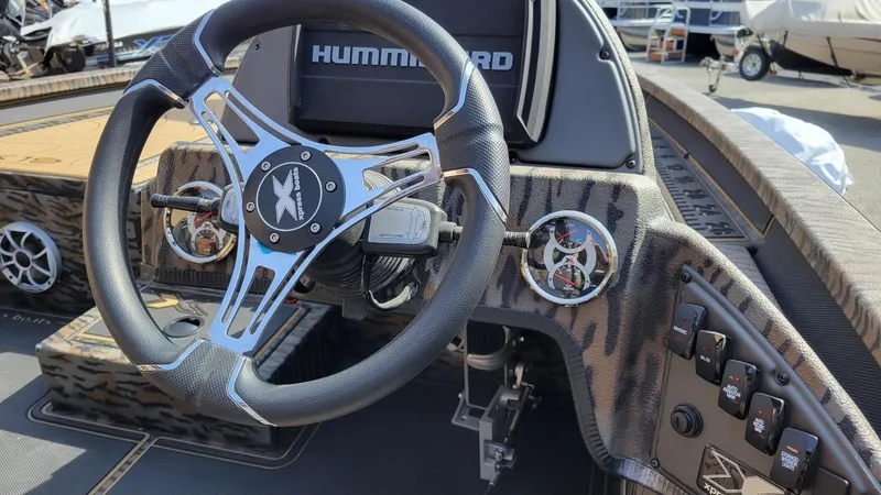 Slide: The Image of 2025 Xpress X19 Pro Bass boat dashboard with steering wheel and controls. - 18