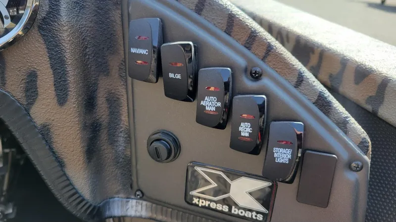 Slide: The Image of Control panel of 2025 Xpress X19 Pro Bass boat with various switches. - 8