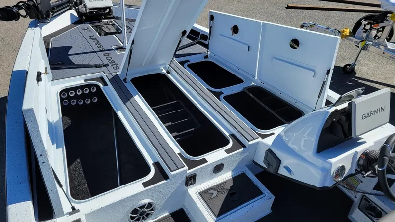Slide: The Image of 2025 Xpress X21 Pro Bass LE boat interior with storage compartments and Garmin system. - 19
