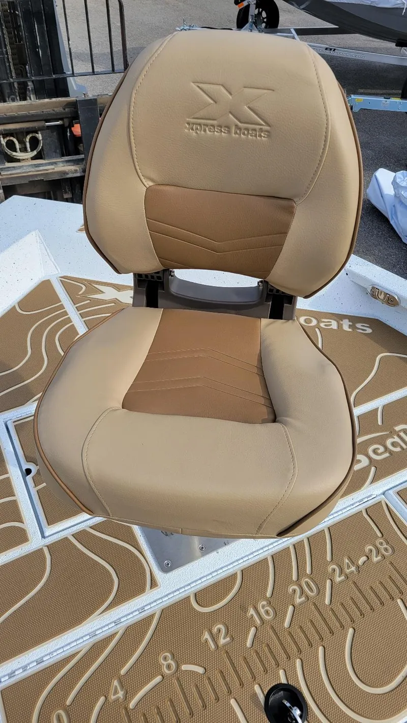 Slide: The Image of 2025 Xpress X23 Bay boat seat with tan upholstery and embossed logo. - 6