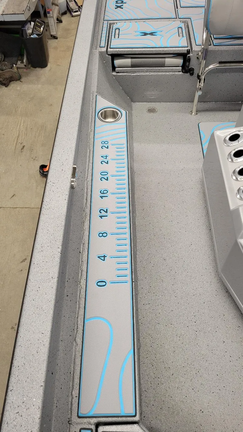 Slide: The Image of 2025 Xpress H22 Bay boat interior with built-in measuring ruler and cup holder. - 13