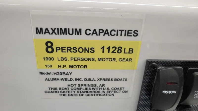 Slide: The Image of 2025 Xpress H20 Bay boat capacity label, 8 persons, 1128 lbs, 150 HP motor. - 21