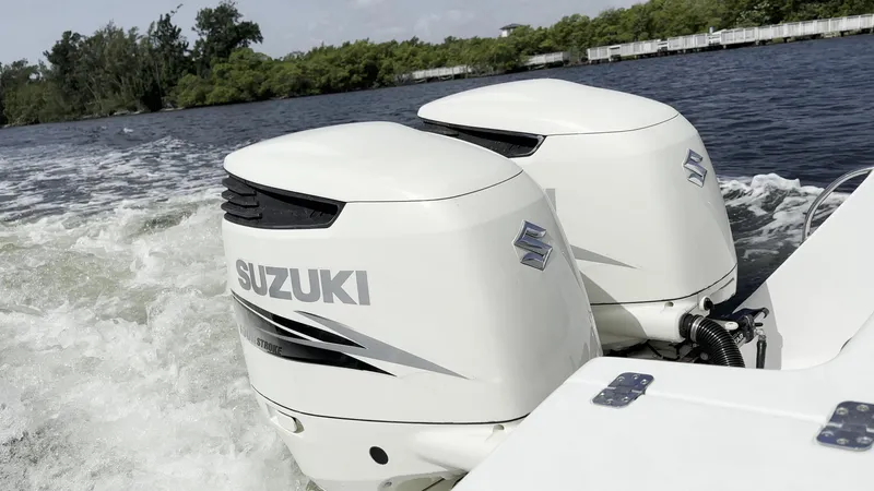 Slide: The Image of Twin Suzuki outboard motors on a 2003 Intrepid 32 boat in motion. - 1