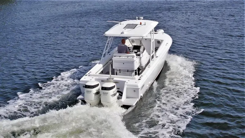 Slide: The Image of 2003 Intrepid 32 boat cruising on open water, rear view with dual engines. - 10