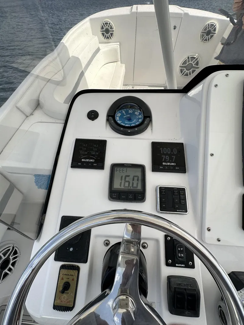 Slide: The Image of 2003 Intrepid 32 boat dashboard with steering wheel and navigation instruments. - 11