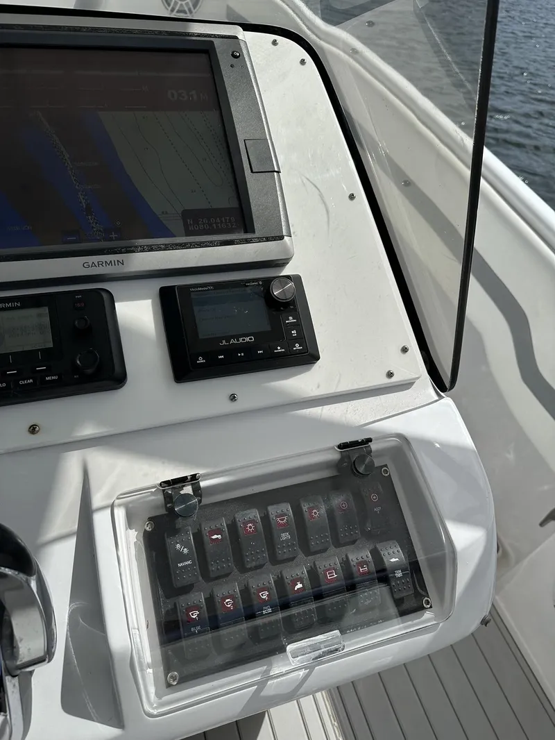 Slide: The Image of 2003 Intrepid 32 boat dashboard with navigation controls and display screen. - 14