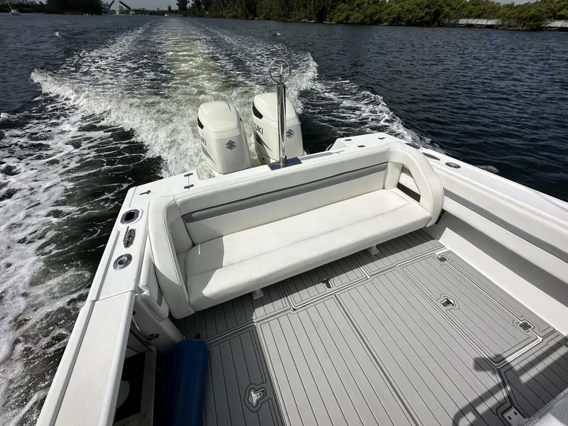 Slide: The Image of 2003 Intrepid 32 boat cruising on water, featuring dual outboard motors and spacious seating. - 17