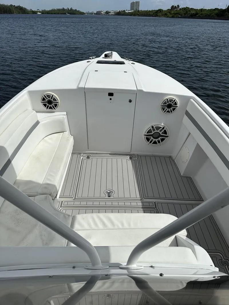 Slide: The Image of 2003 Intrepid 32 boat interior with white seating and speakers on calm water. - 20