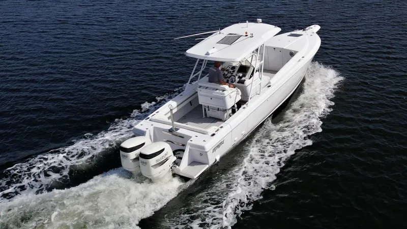 Slide: The Image of 2003 Intrepid 32 boat cruising on open water, rear view. - 21