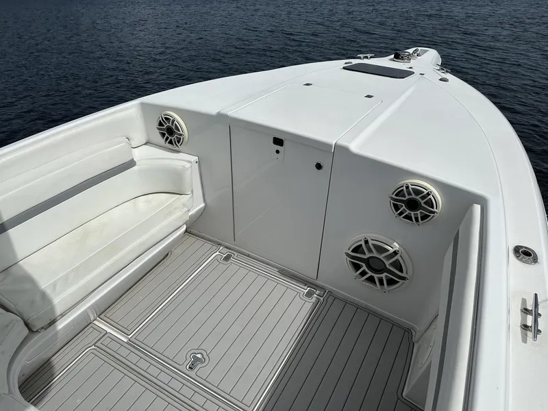 Slide: The Image of 2003 Intrepid 32 boat interior with seating and speakers on calm water. - 24