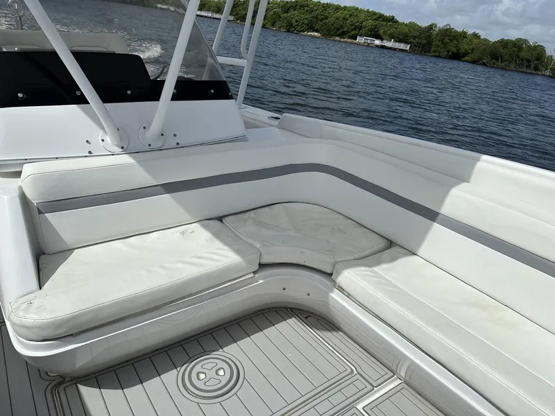 Slide: The Image of 2003 Intrepid 32 boat with white cushioned seating on a calm lake. - 25