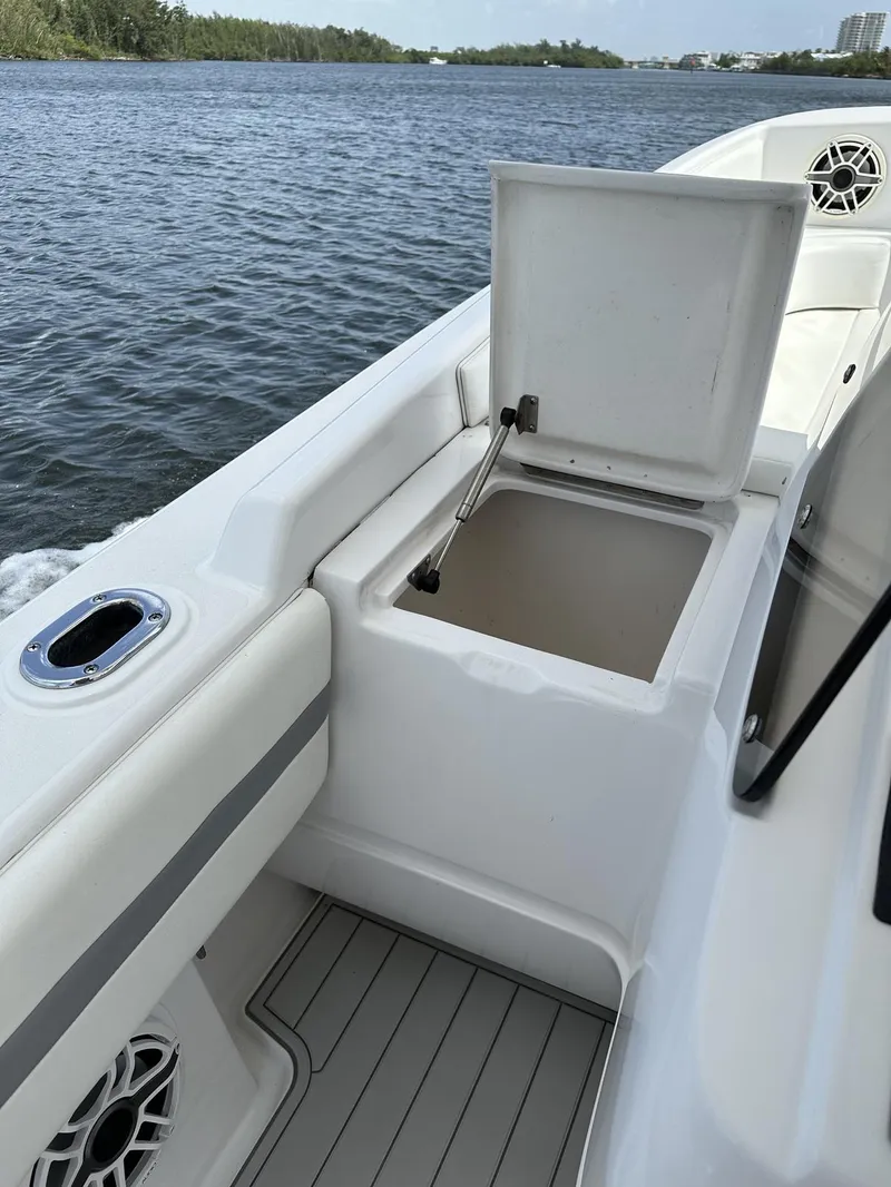 Slide: The Image of 2003 Intrepid 32 boat with open storage compartment on deck, near water. - 26