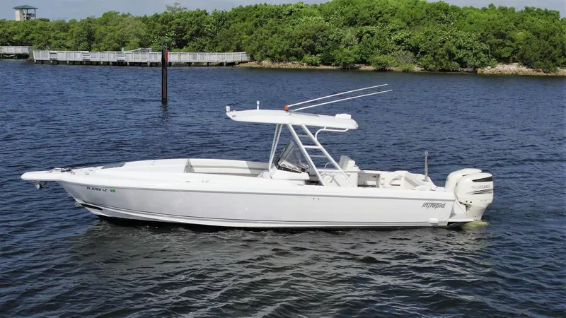 Slide: The Image of 2003 Intrepid 32 boat on calm water with lush green shoreline in the background. - 27