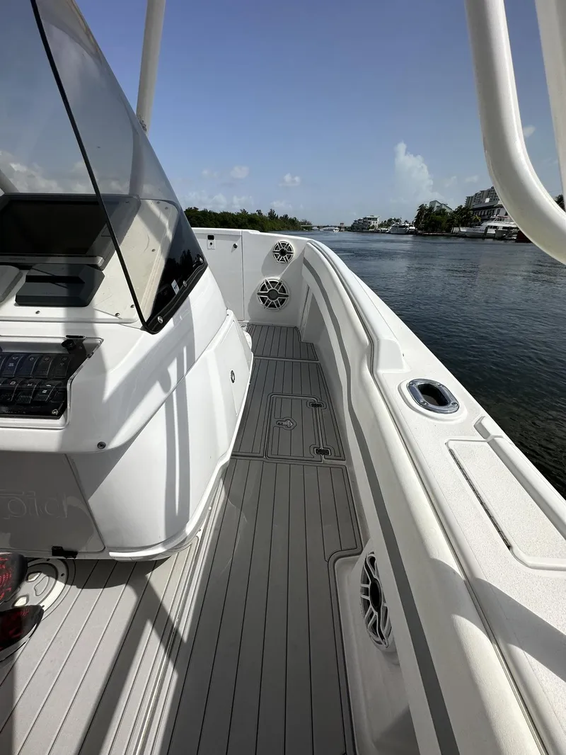 Slide: The Image of 2003 Intrepid 32 boat deck with sleek design, cruising on a calm waterway. - 29