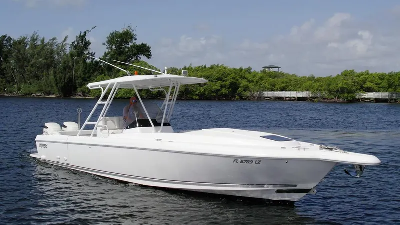 Slide: The Image of 2003 Intrepid 32 boat cruising on a calm river with lush greenery in the background. - 32