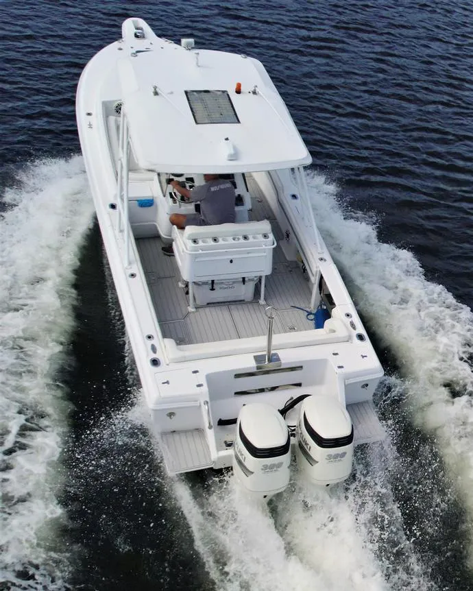 Slide: The Image of 2003 Intrepid 32 boat cruising on open water, rear view. - 44