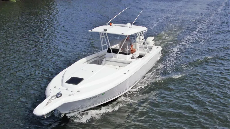 Slide: The Image of 2003 Intrepid 32 boat cruising on water, featuring sleek white design and spacious deck. - 47