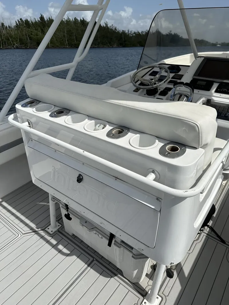 Slide: The Image of 2003 Intrepid 32 boat interior with helm, seating, and rod holders on a sunny day. - 8