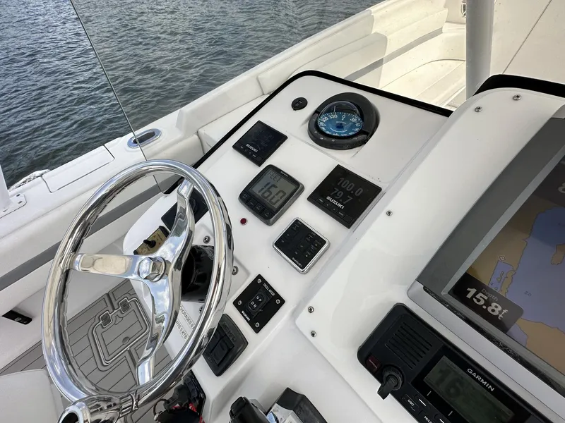 Slide: The Image of Control panel of a 2003 Intrepid 32 boat with navigation instruments and steering wheel. - 9