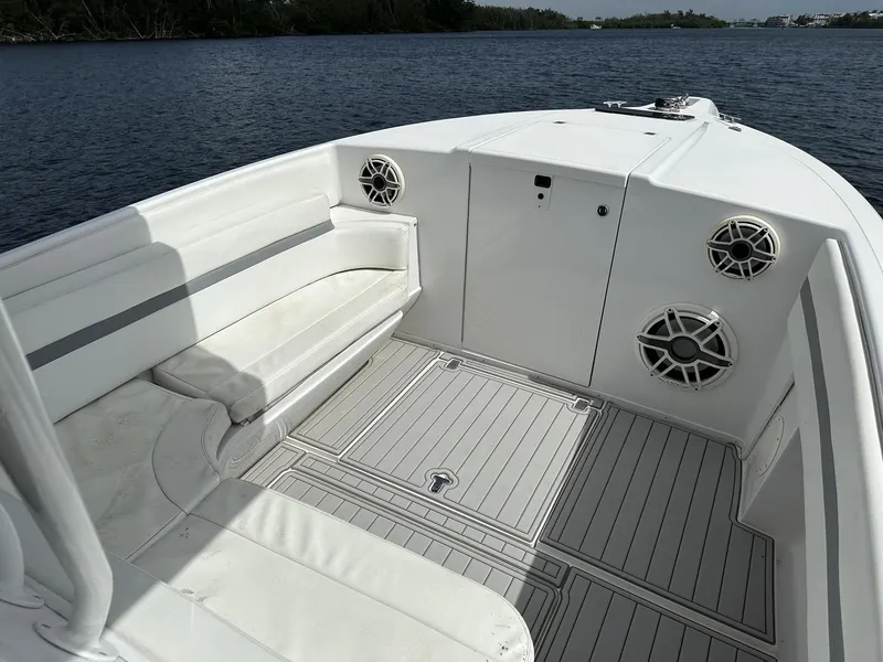 Slide: The Image of 2003 Intrepid 32 boat interior with white seating and speakers on a calm lake. - 22