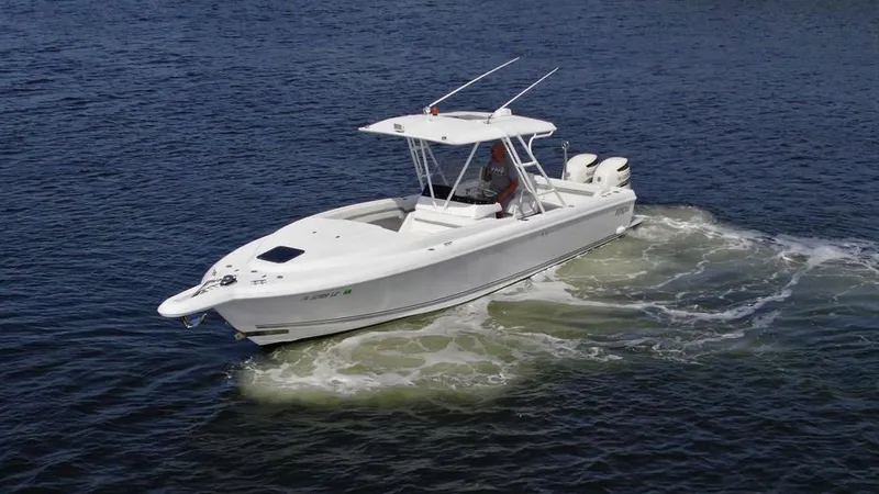 Slide: The Image of 2003 Intrepid 32 boat cruising on open water, featuring twin engines and a sleek design. - 28