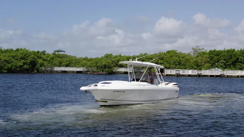 Slide: The Image of 2003 Intrepid 32 boat cruising on a calm river with lush greenery. - 30