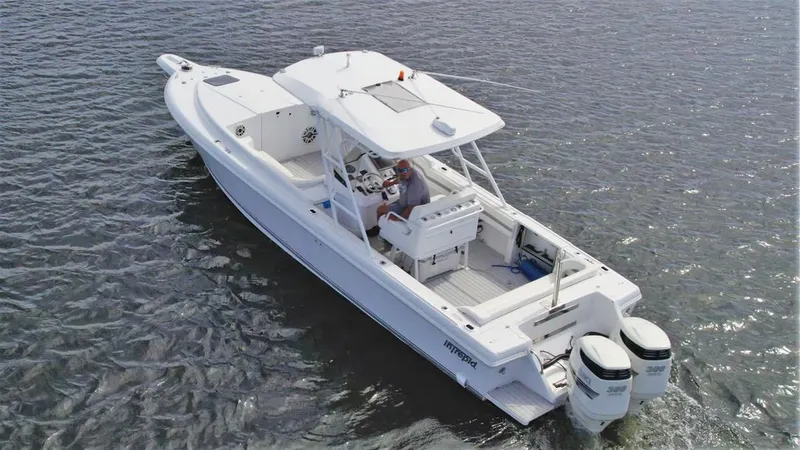 Slide: The Image of 2003 Intrepid 32 boat on water, featuring dual outboard motors and spacious deck. - 40