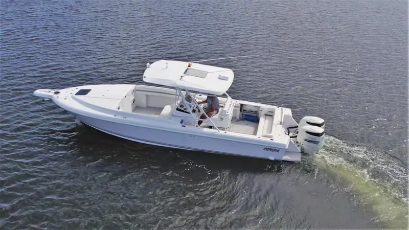 Slide: The Image of 2003 Intrepid 32 boat cruising on open water, featuring dual outboard engines. - 41