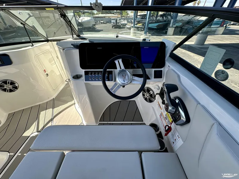 Slide: The Image of 2025 Sea Ray SDX 250 Surf boat interior with modern dashboard and steering wheel. - 13