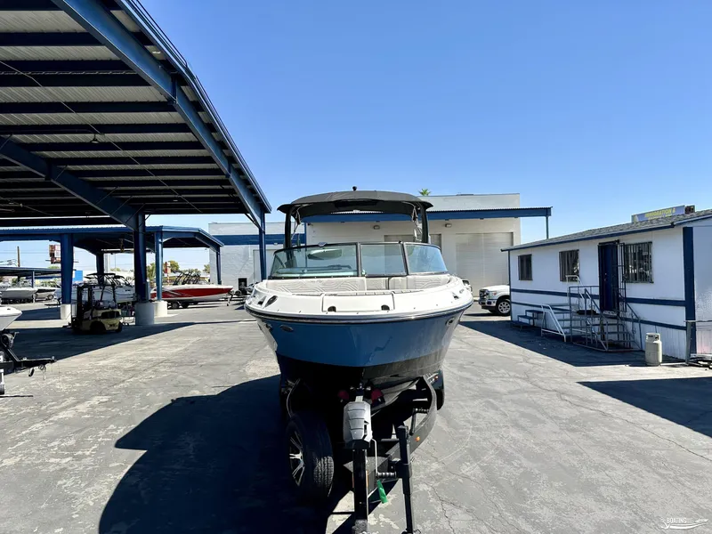 Slide: The Image of 2025 Sea Ray SDX 250 Surf boat on trailer in outdoor showroom. - 2