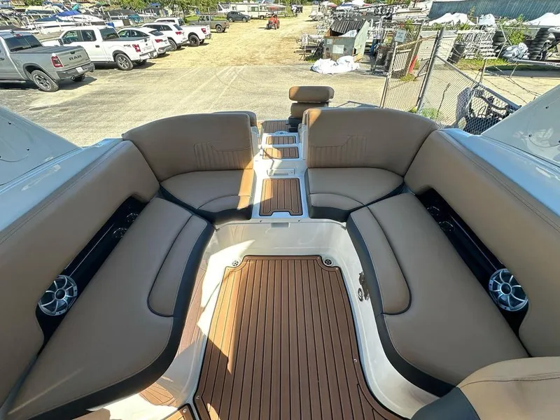 Slide: The Image of 2025 Crownline 270 SS boat interior with tan seating and wood flooring. - 15