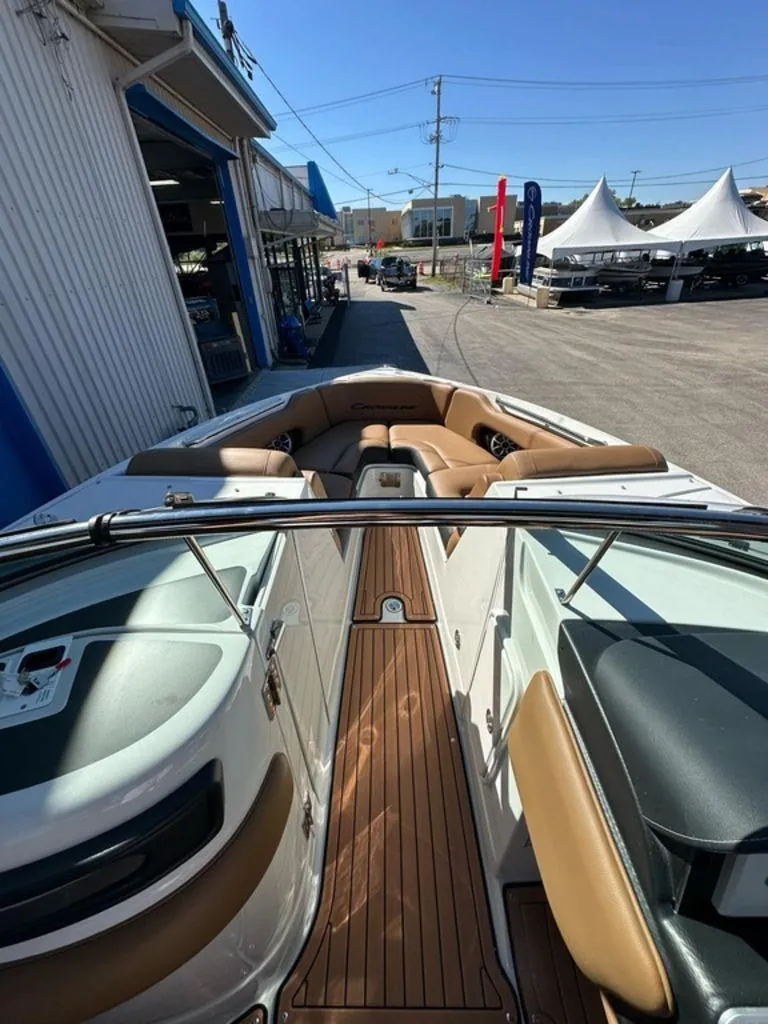 Slide: The Image of 2025 Crownline 270 SS boat interior with tan seating and wood flooring. - 4